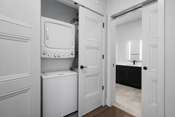A washer and dryer in a laundry room with a bathroom in the background